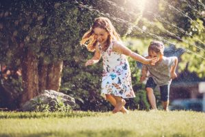 children-play-in-yard-sprinkler